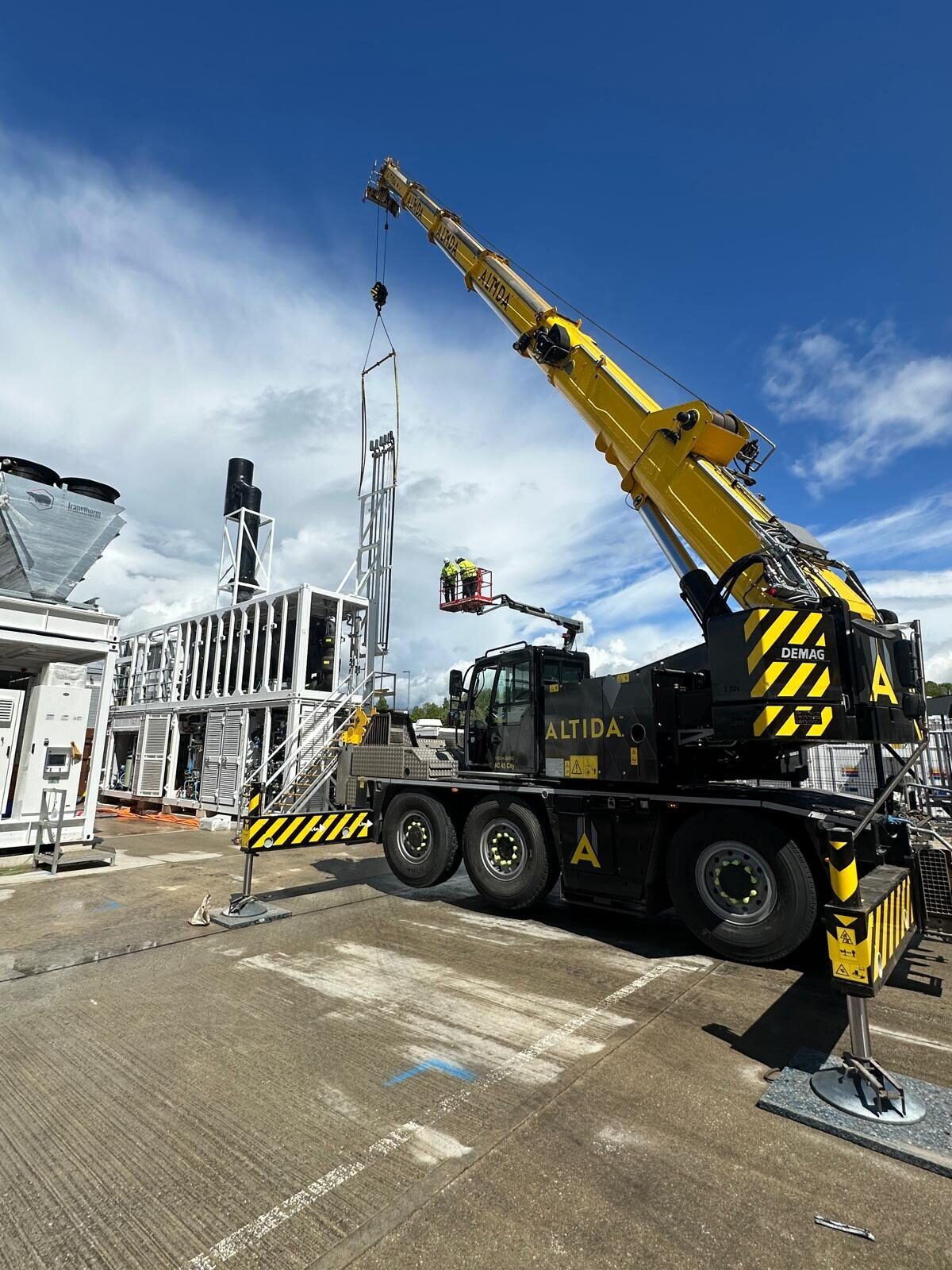 The Demag AC 45 City lifting delicate pipework on a Mod 6 spreader beam into an energy-storage unit at Sheffield, engineers on a platform alongside